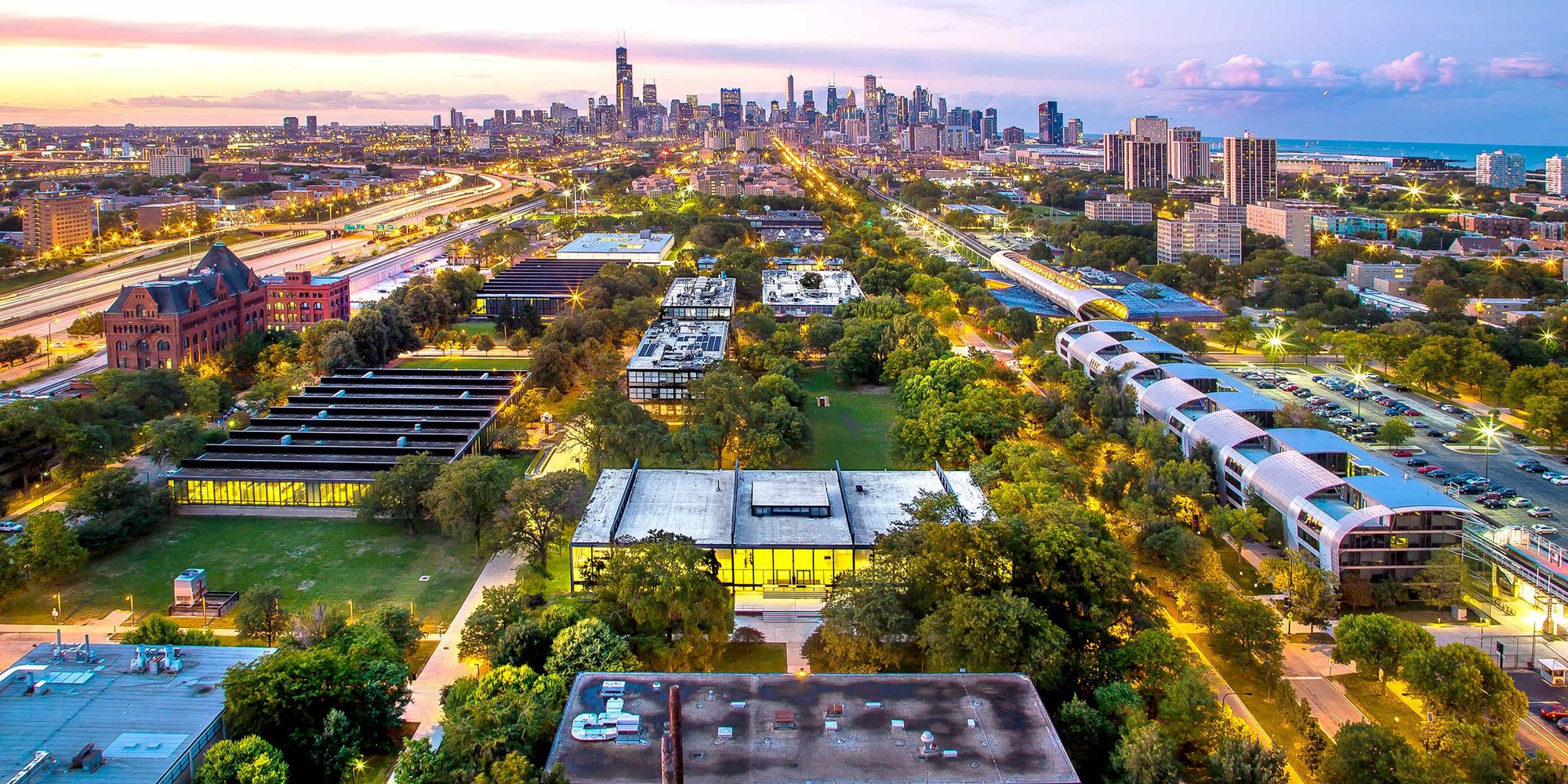 Illinois Tech campus at dusk with the Chicago skyline behind it